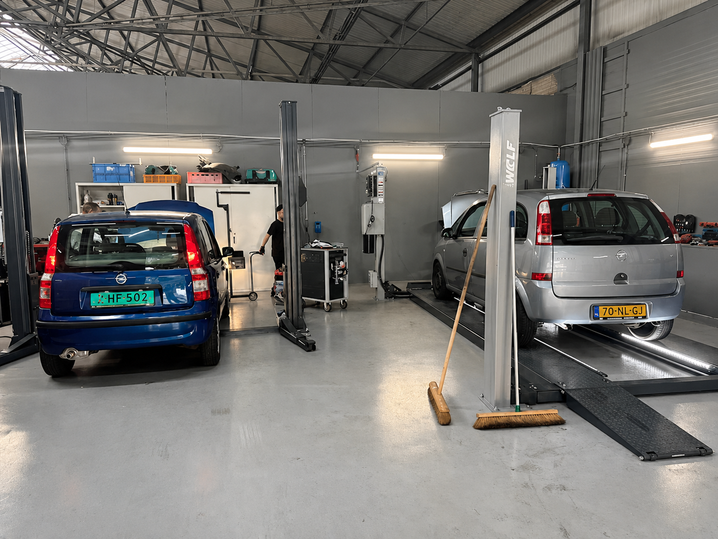 Onze werkplaats in Nieuw-Vennep met twee auto's op de hefbrug
